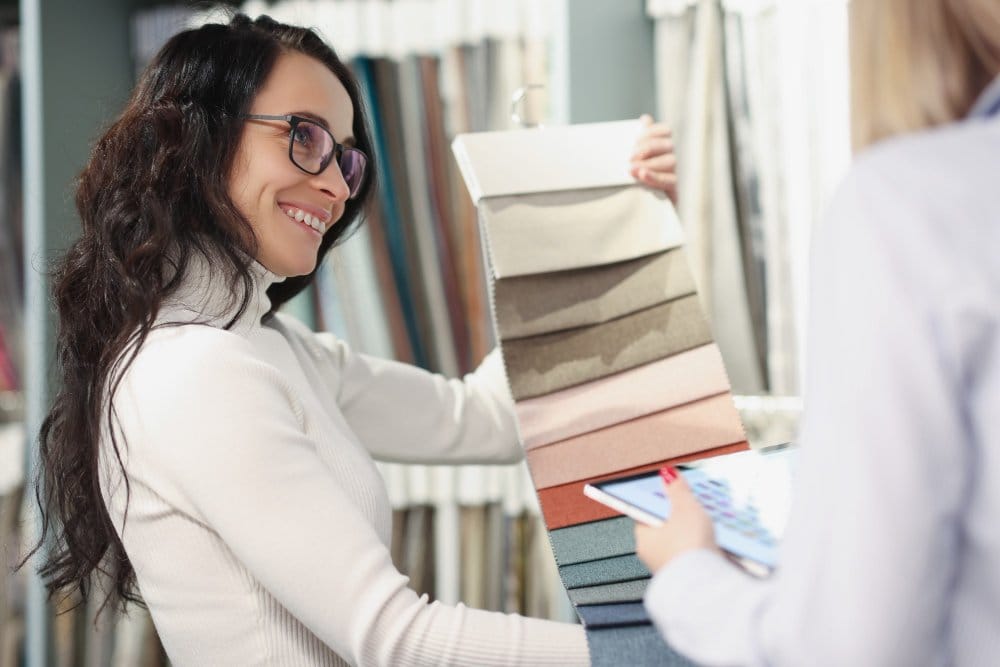 Woman selecting fabric swatches in textile store