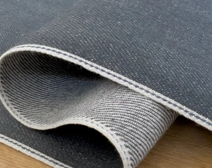 Japanese selvedge denim fabric with visible selvedge edge and textured indigo denim weave
