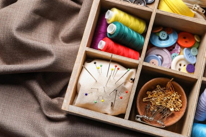 organized sewing storage box with threads pins buttons and sewing accessories