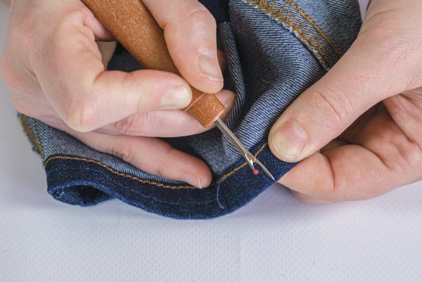 Removing stitches from denim fabric using a seam ripper tool