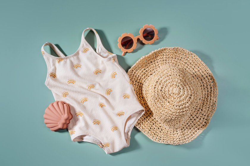 Lightweight baby summer clothing including cotton onesies, sun hats, and breathable rompers