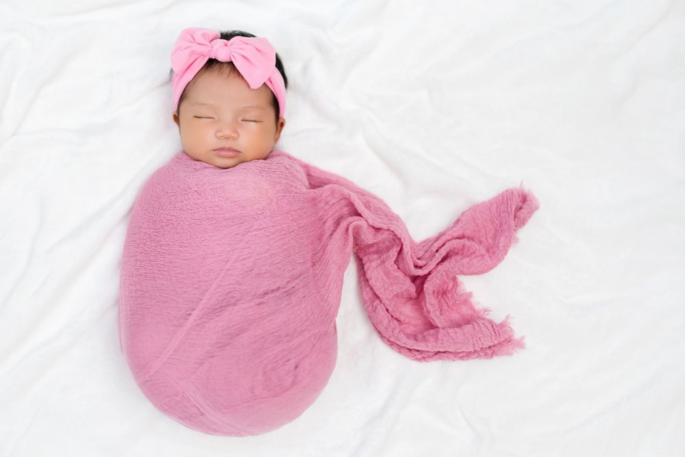 Newborn baby swaddling techniques and safe sleep wear options
