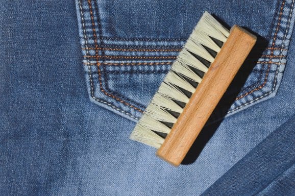 denim jeans ready to be cared for with a brush