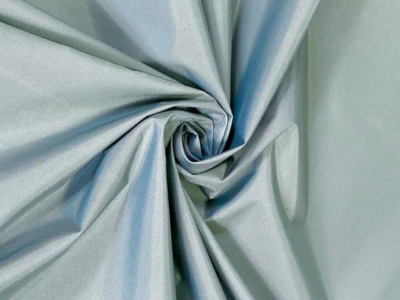 Smooth light blue nylon fabric with soft sheen and structured swirl texture durable synthetic textile material