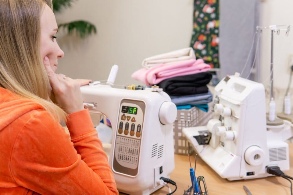 Sewist adjusting sewing machine settings and stitch controls for accuracy