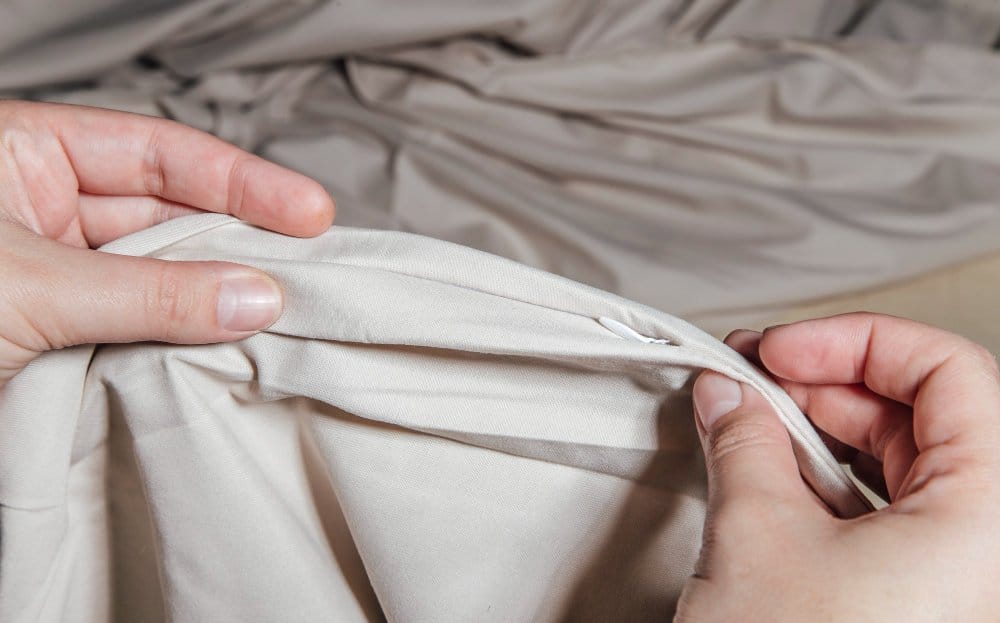 Hands inspecting fabric seam and weave structure closely