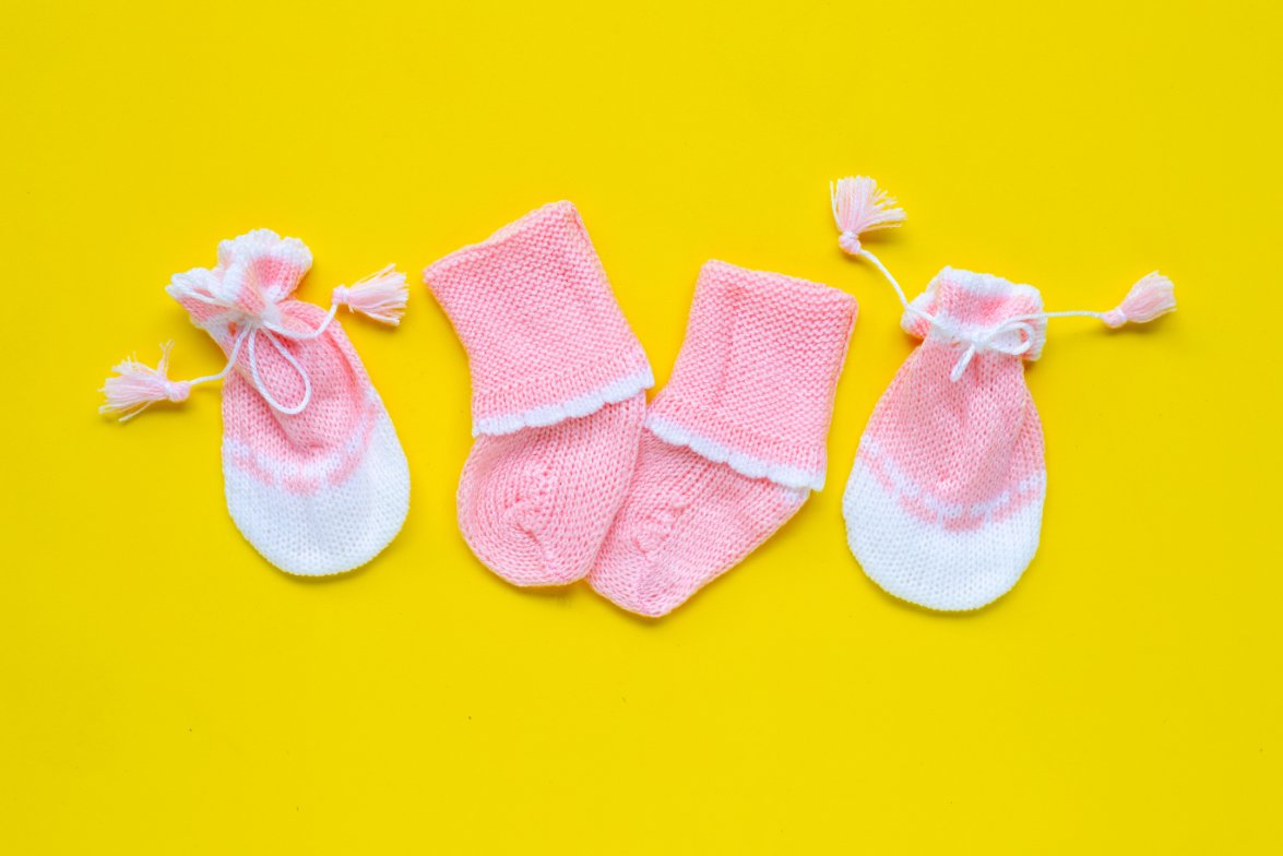 Collection of preemie accessories including tiny hats, mittens, booties, and socks designed for premature babies