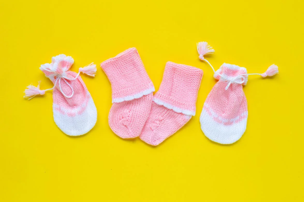 Collection of preemie accessories including tiny hats, mittens, booties, and socks designed for premature babies