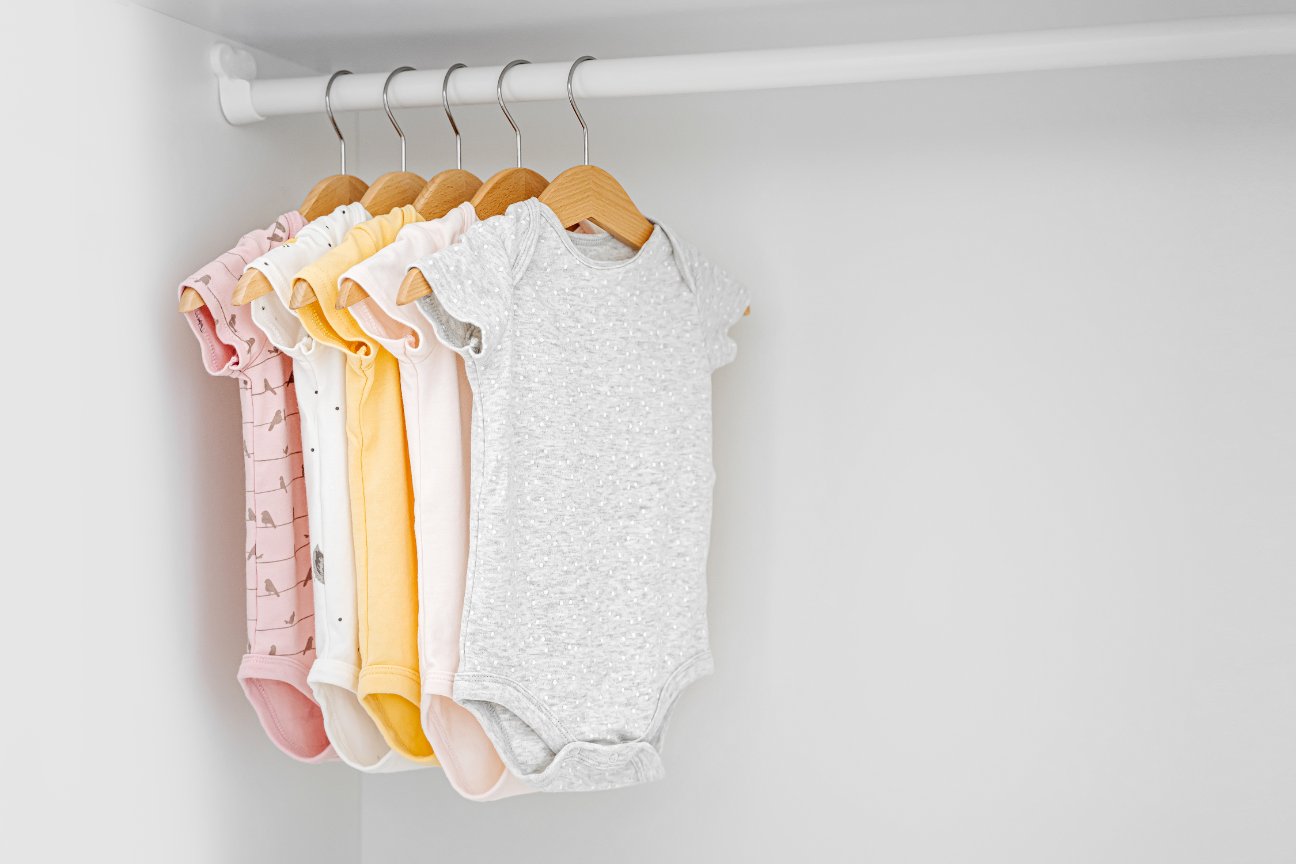 Colorful array of onesies and bodysuits arranged on shelves with various designs and sizes