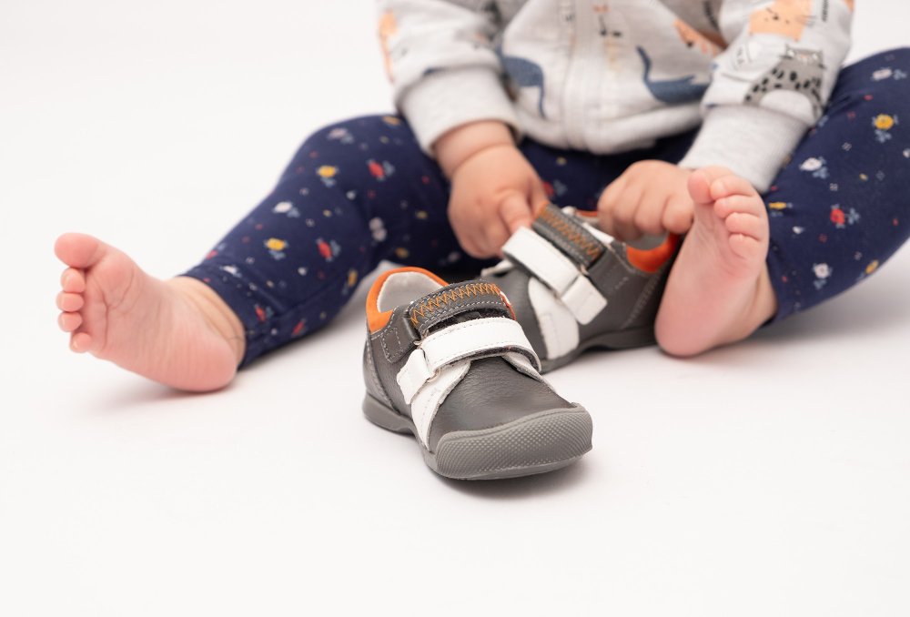 Various types of toddler shoes including sneakers, sandals, and boots arranged for different activities and seasons