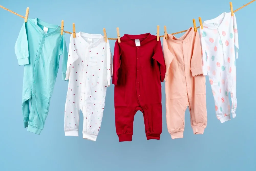 Cute colorful hand me down baby clothing hung on a rope