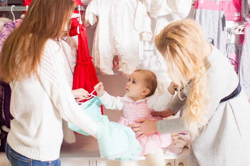 A mother shopping for a dress with her toddler