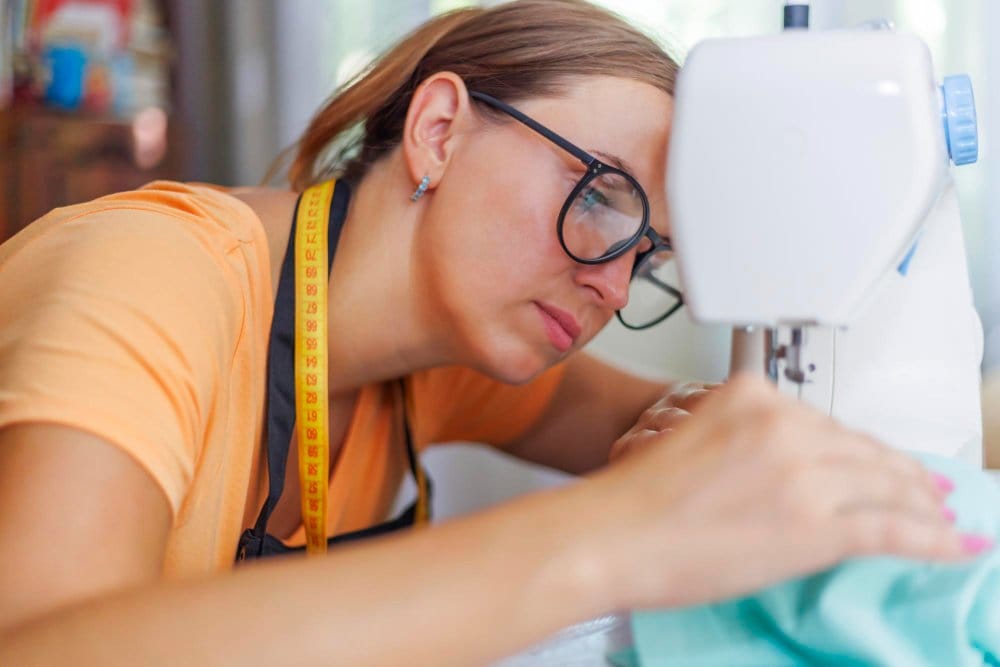 a seamstress fully focused on sewing on a machine