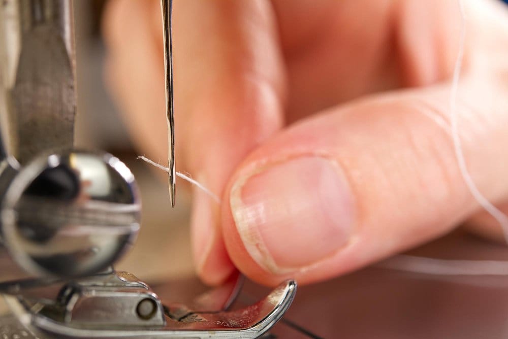 a string being put carefully in a niddle