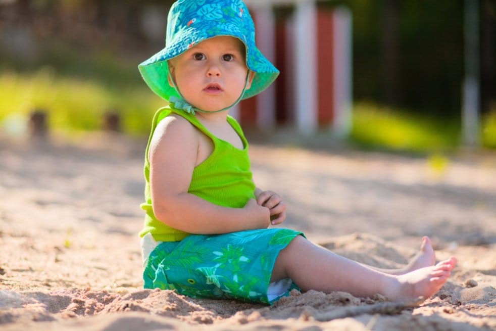toddler sitting on a beach sand