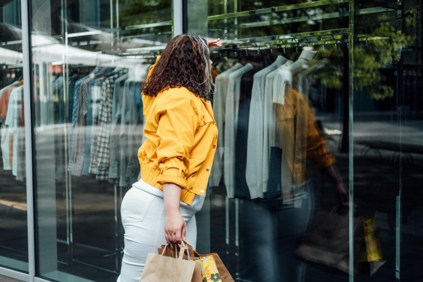 A woman walking into a clothing shop