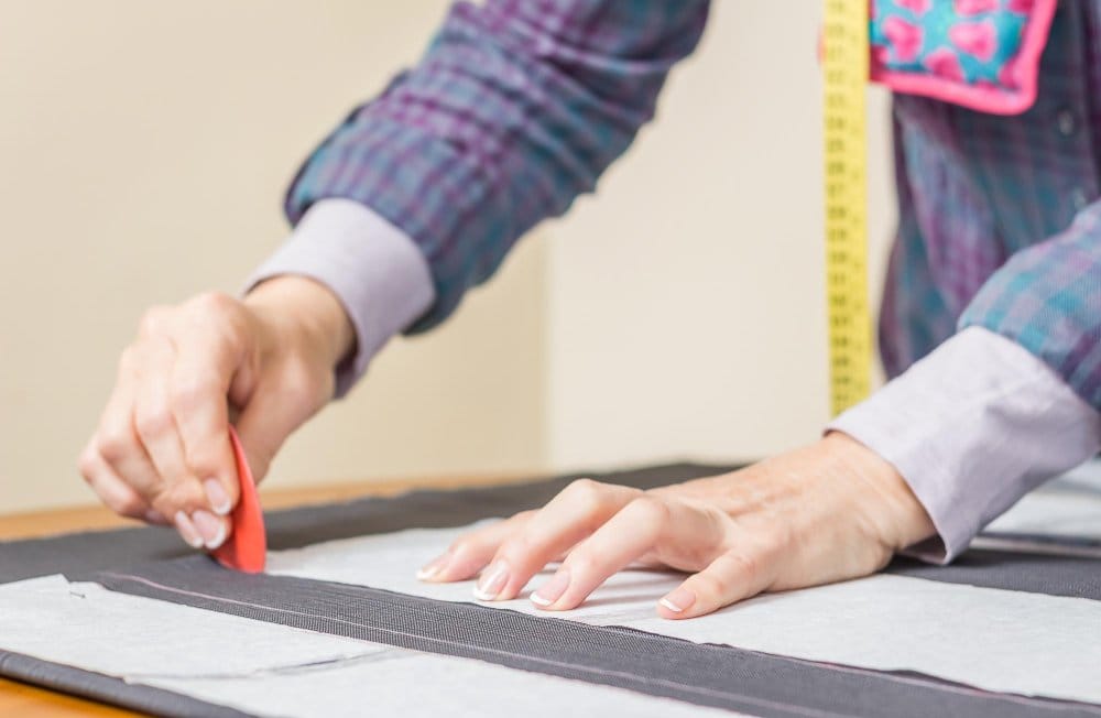 A seamstress cutting a fabric perfectly