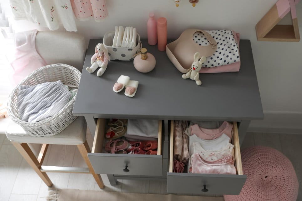 Open cabinet drawers with toddler shoes and clothes
