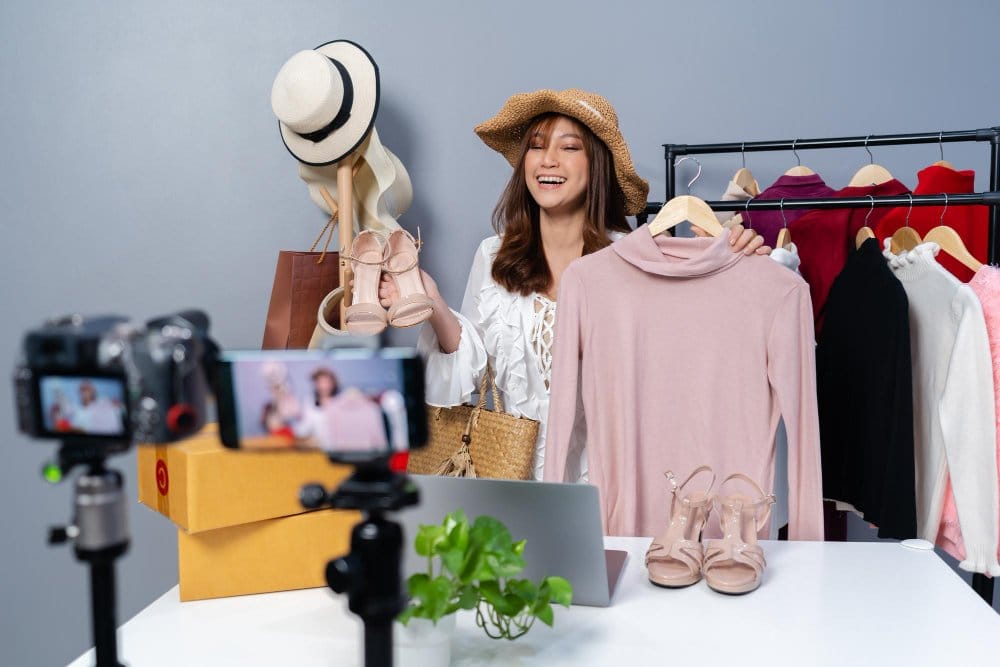 a young influencer doing a live video displaying different clothing items