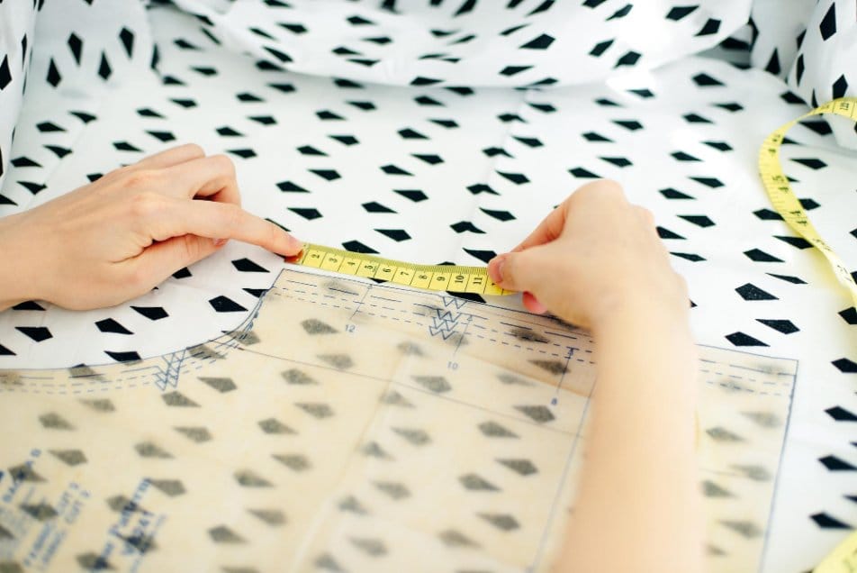 A seamstress cuts detail on sketch