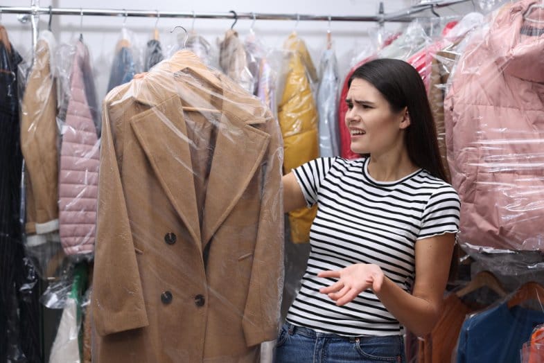 Confused shopper examining coat label in clothing store