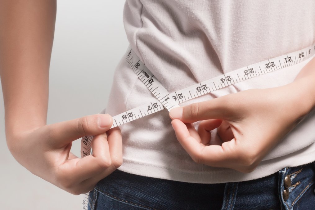 Professional woman demonstrating proper jacket fit and measuring techniques