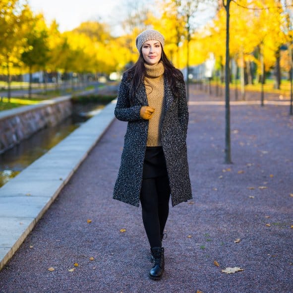 A woman wearing a cozy winter outfit with layers of warm fabrics: wool, fleece, creating a sense of comfort and protection against the cold