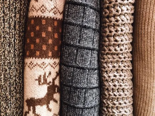a pile of warm fabrics such as wool, fleece, and knit