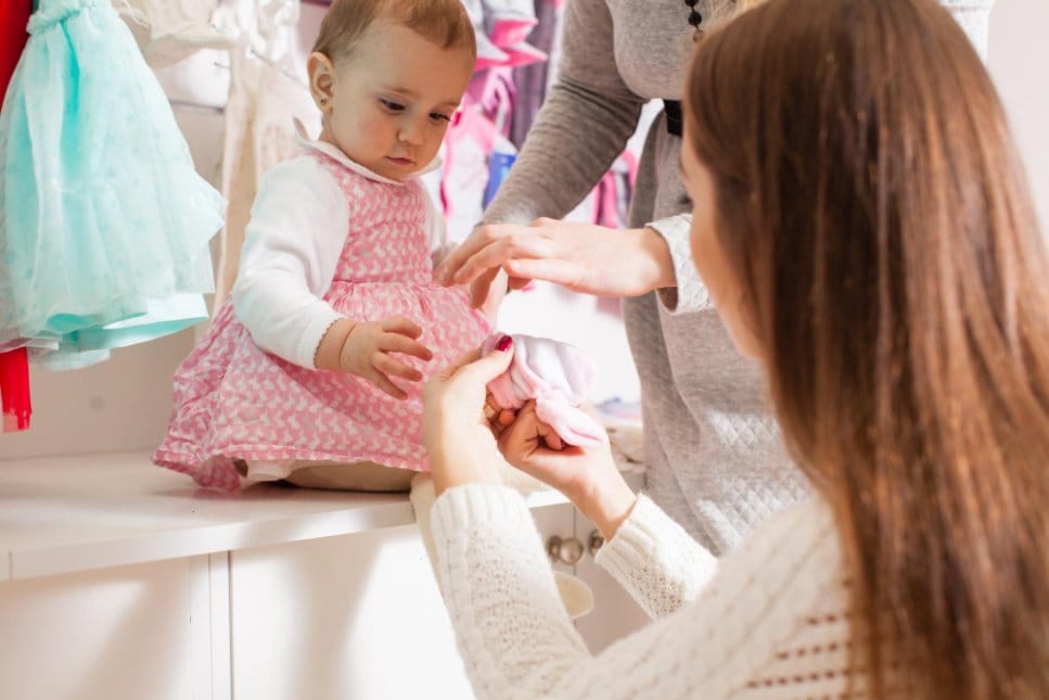 Mother checking the size of an item for her toddler in a clothing store
