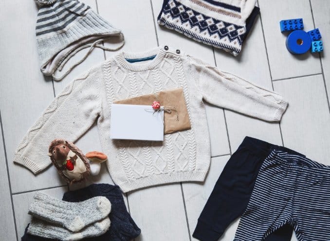 Different types of toddler clothing including a long sleeve top, pants socks and hat