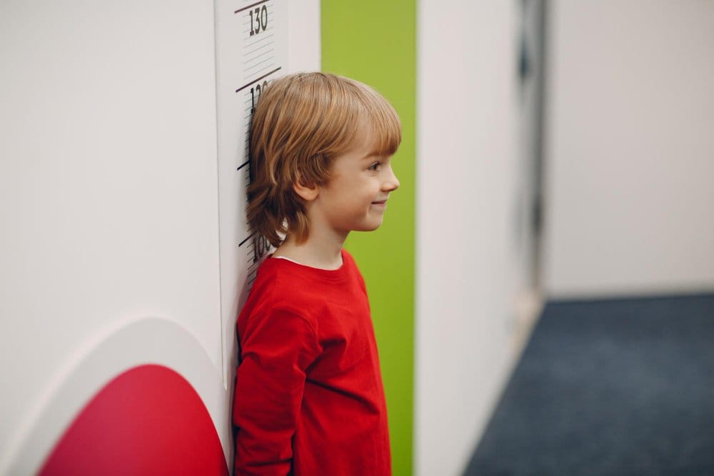 toddler boy measuring his height