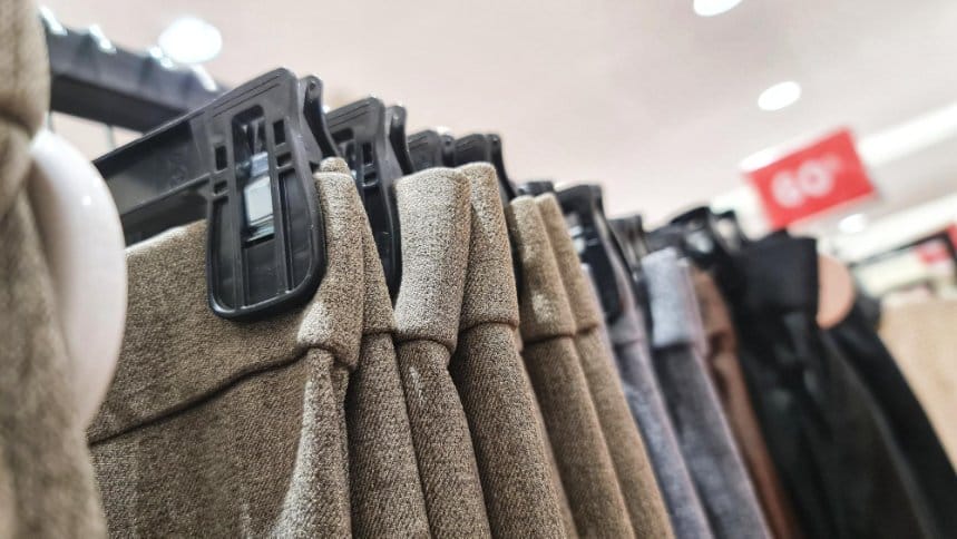 A row of different types of pants and trousers neatly displayed on a clothing rack