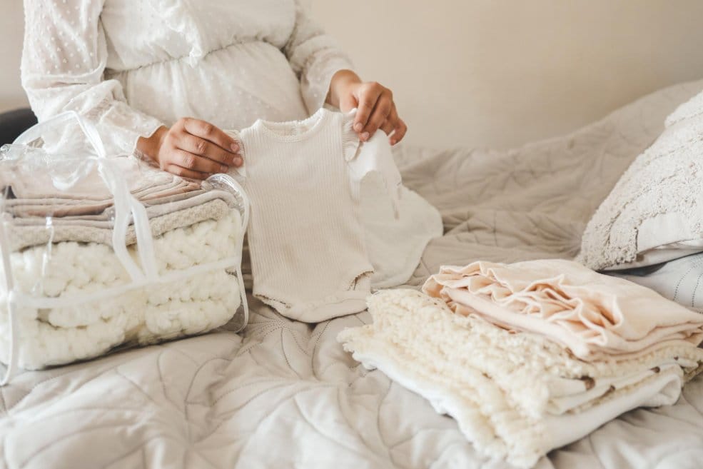 Pregnant woman sorting baby clothes