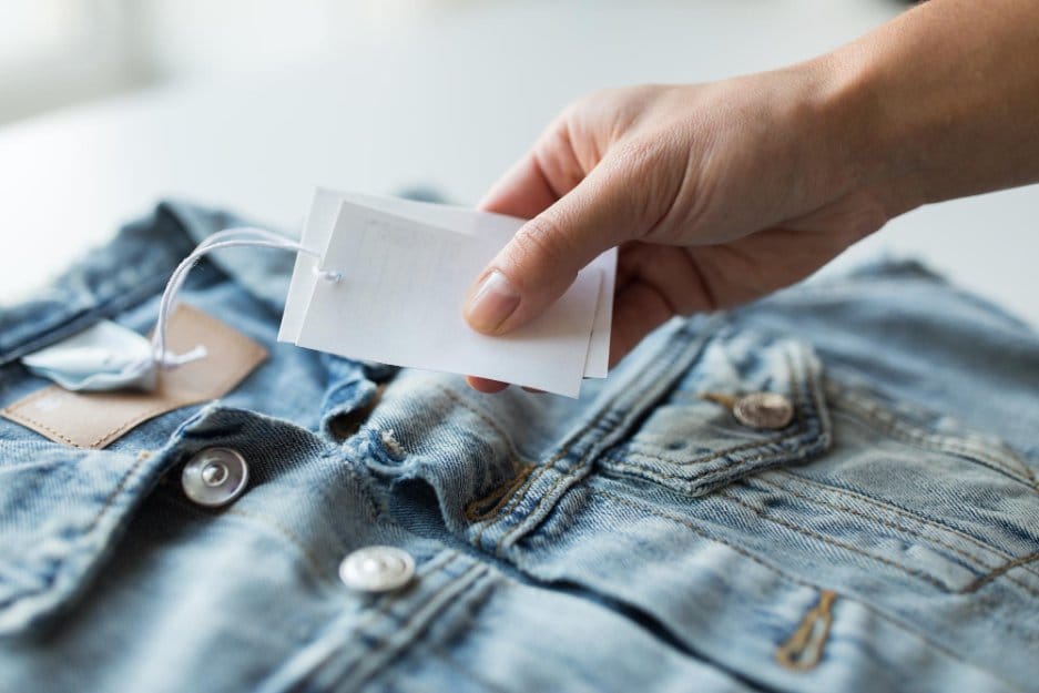 close up of a hand holding a label of kids denim jacket