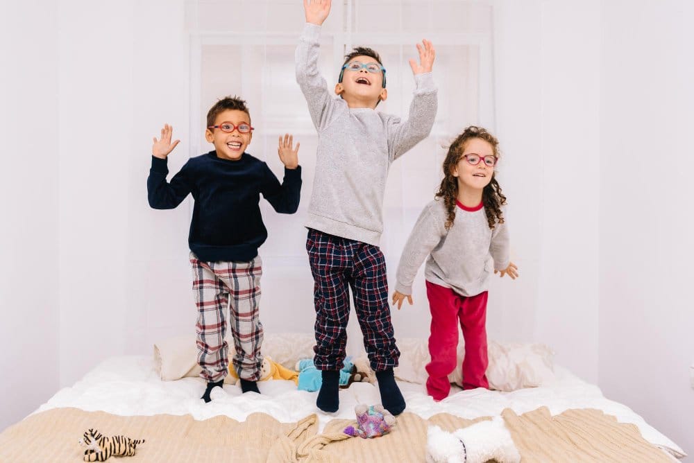 Three kids wearing a pajamas and playing