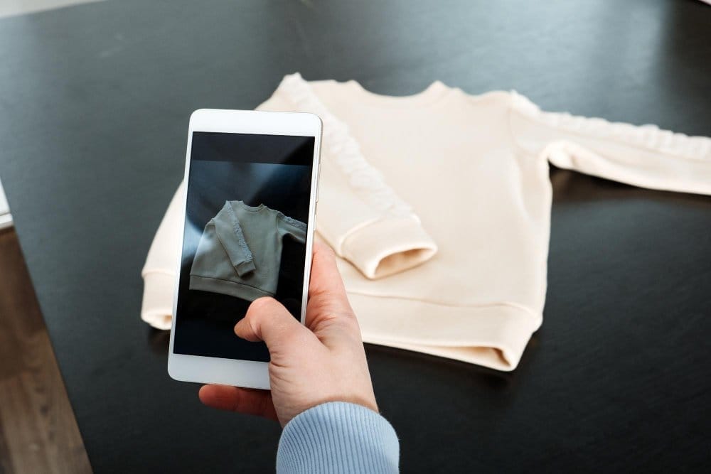 Taking a clear product photo of a children's sweatshirt with a smartphone for a Vinted listing