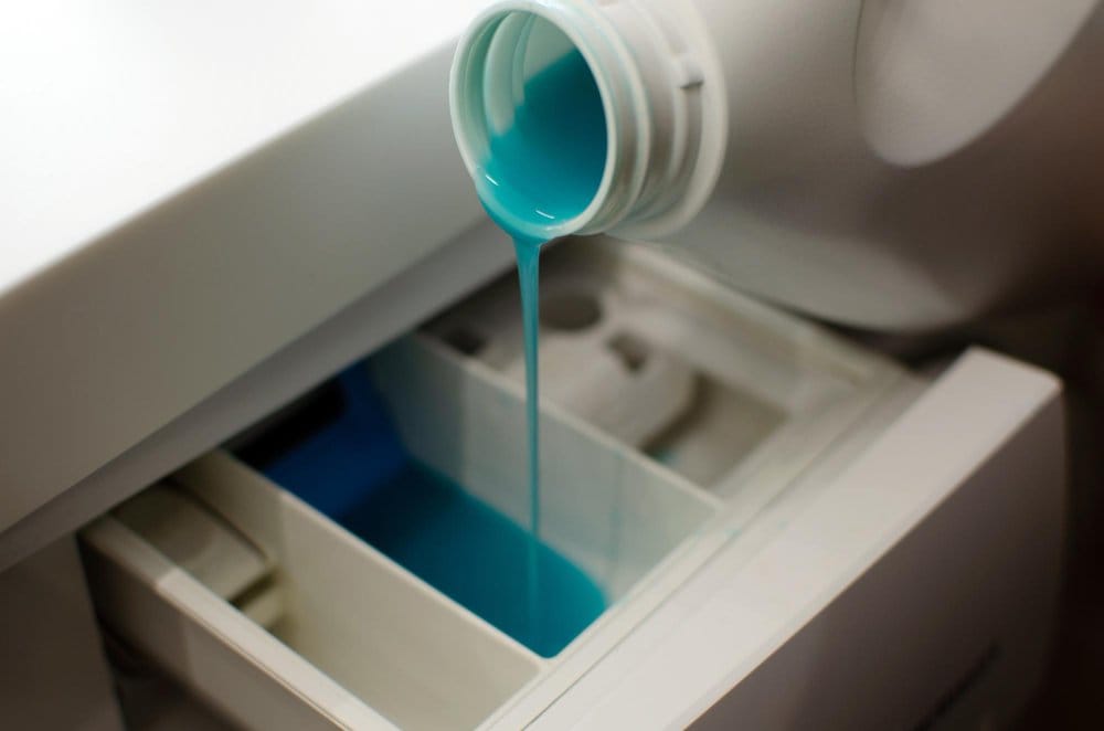 Fabric softener being poured in a washing machine