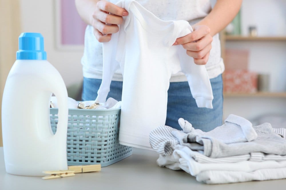 A woman preparing baby clothes for washing