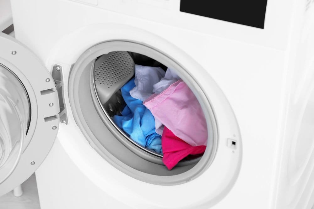 A washing machine loaded with baby clothes