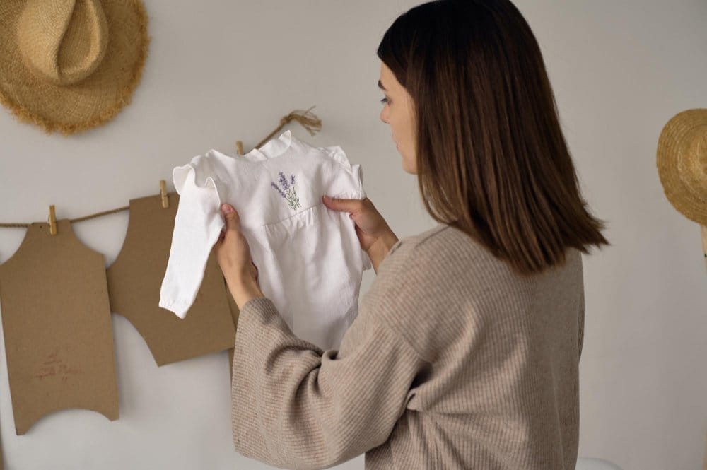 Parent checking the fit and fabric of a baby outfit at home to ensure comfort and safety