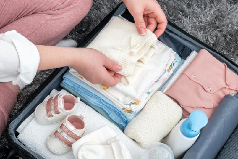 neatly folded toddler clothes and accessories in a suitcase