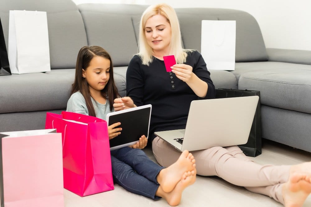 happy mother and daughter with laptop computer, shopping online for daycare supplies