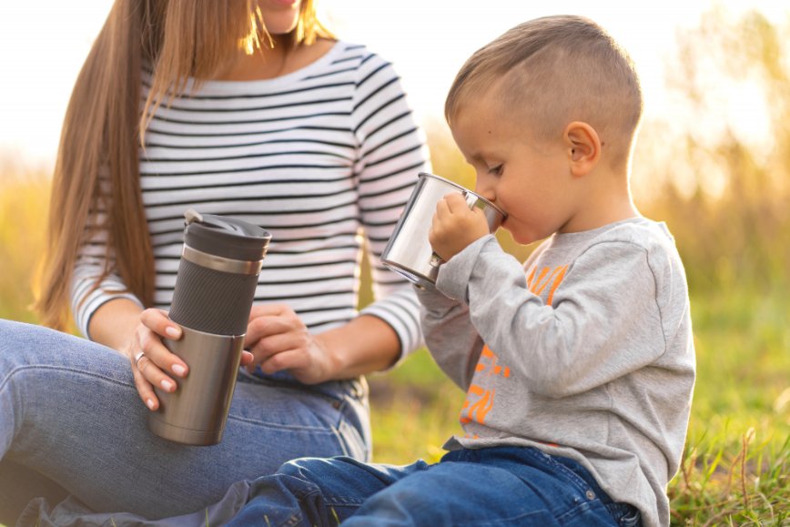 Mother and son on a hiking and son drinking from a cup