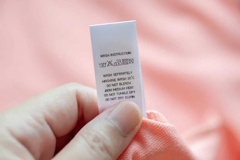 Toddler clothing with visible care label tags showing washing symbols and instructions