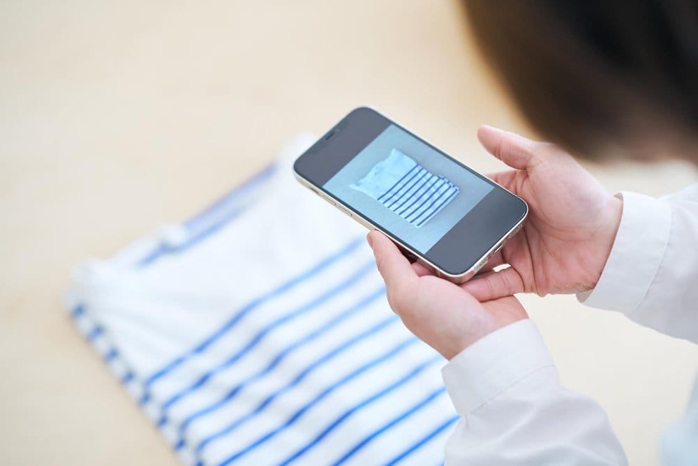 Seller reviewing toddler outfit photo on smartphone to improve resale value