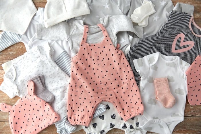 Flat lay of second hand baby clothes and toddler outfits