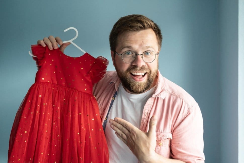 Happy parent holding red toddler dress after successful resale