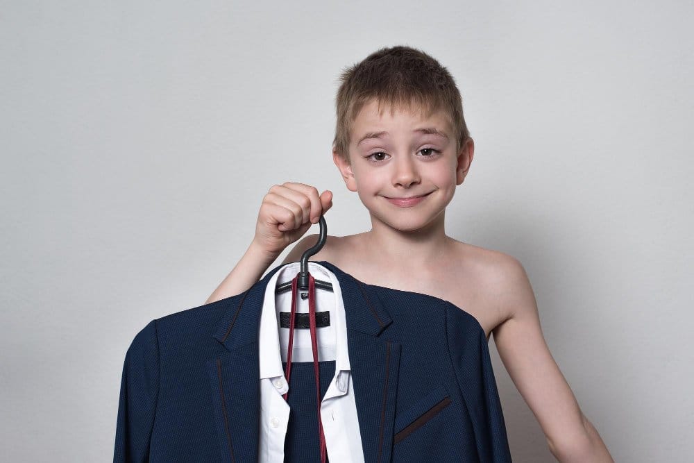 Little boy smiling and proud of his chosen outfit