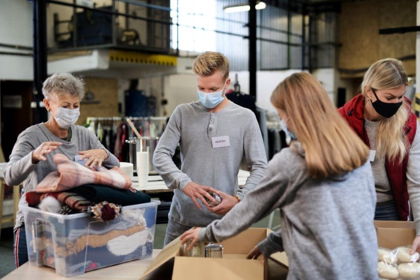 Group of volunteers in community charity donation center for toddler clothing