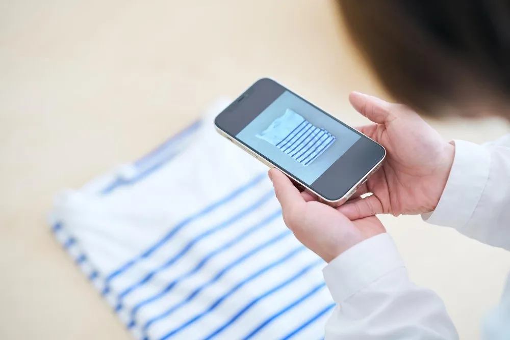 Woman photographing clothes with smartphone